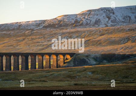 Luce d'oro che colpisce il magnifico Viadotto Ribblehead nello Yorkshire Dales Foto Stock