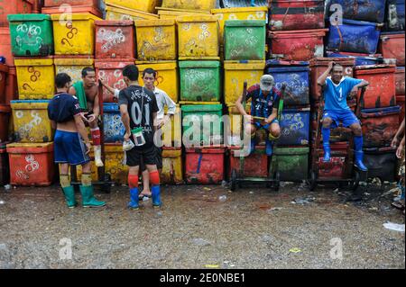 28.06.2014, Yangon, Myanmar, Asia - lavoratori con carretti a mano di fronte a colorate scatole di raffreddamento al tradizionale mercato del pesce di Baho San Pya. Foto Stock