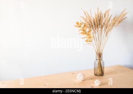 Fiori secchi in vaso di vetro con luce vuota parete per un decor minimalista Foto Stock