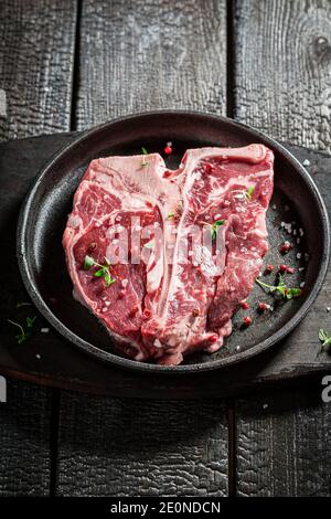 Bistecca fresca e rossa con sale ed erbe bruciate tabella Foto Stock