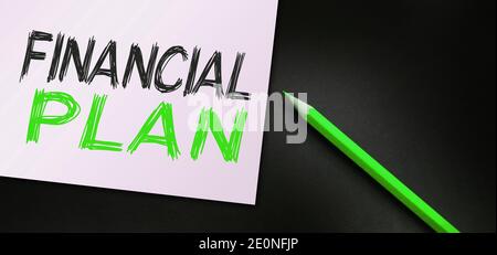 Testo del piano finanziario scritto su taccuino e matita arancione. Concetto aziendale. Foto Stock