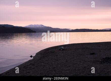 Ben Lomond a Loch Lomond durante il cielo rosa dell'alba Scozia Foto Stock