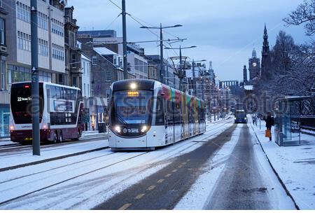 Edimburgo, Scozia, Regno Unito. 2 gennaio 2021. La neve cade poco prima dell'alba nel centro della città. Tram e autobus in Princes Street. Credit: Craig Brown/Alamy Live News Foto Stock