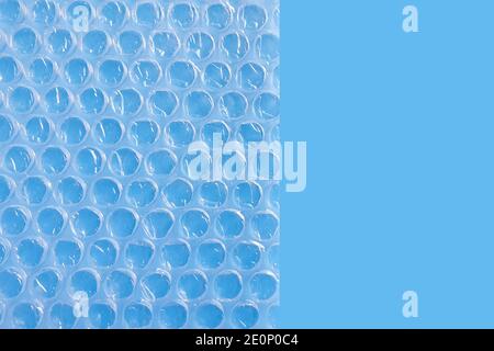 Imballaggio a bolle d'aria o pellicola cuscino d'aria su sfondo blu. Foto Stock