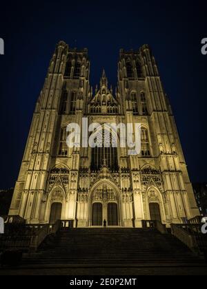 Persona davanti alla facciata illuminata di brabantino gotico cattolico chiesa cattedrale di San Michele e San Gudula a Bruxelles Belgio Europa Foto Stock