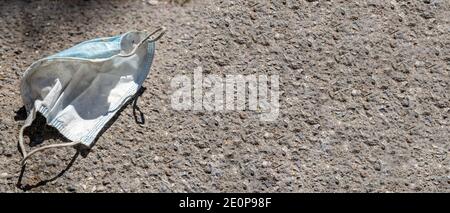 Maschera medica sprecata sul marciapiede in strada, spazio di copia Foto Stock