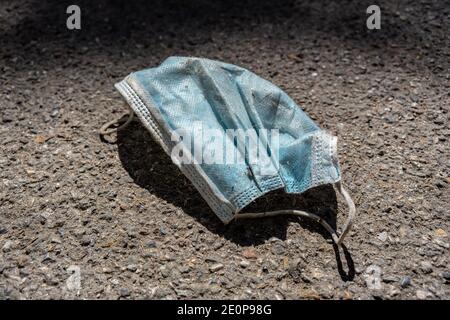 Maschera medica sprecata sul marciapiede in strada, spazio di copia Foto Stock