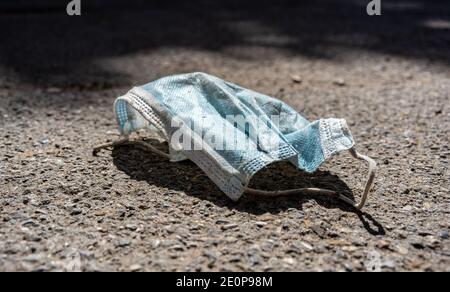 Maschera medica sprecata sul marciapiede in strada, spazio di copia Foto Stock