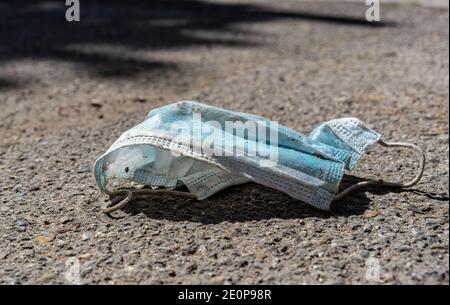 Maschera medica sprecata sul marciapiede in strada, spazio di copia Foto Stock