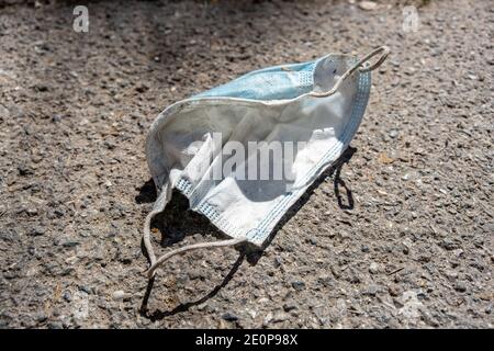 Maschera medica sprecata sul marciapiede in strada, spazio di copia Foto Stock