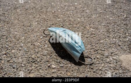 Maschera medica sprecata sul marciapiede in strada, spazio di copia Foto Stock