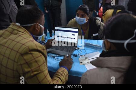 Nuova Delhi, India. 02 gennaio 2021. Un operatore sanitario raccoglie i dati prima di condurre un test di base su un volontario durante una massiccia giornata di esercizio per verificare i modi migliori per vaccinare le persone contro Covid-19 e colmare le lacune nella logistica e nella formazione a Nuova Delhi. La guida di un giorno verificherà la fattibilità operativa nell'uso dell'applicazione CoWIN in un ambiente di campo. L'esercizio viene un giorno dopo che un gruppo di esperti nominati dal governo ha raccomandato l'approvazione per il vaccino Oxford Covid-19 prodotto dal Serum Institute of India. (Foto di Sondeep Shankar/Pacific Press) Credit: Pacific Pre Foto Stock