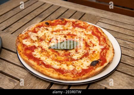 Una deliziosa pizza margarita su un tavolo di legno Foto Stock