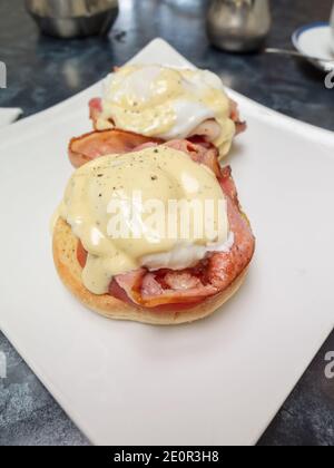 Uova Benedict Canadese pancetta in camicia uovo e pomodoro su un muffin inglese con salsa di Hollandaise Foto Stock