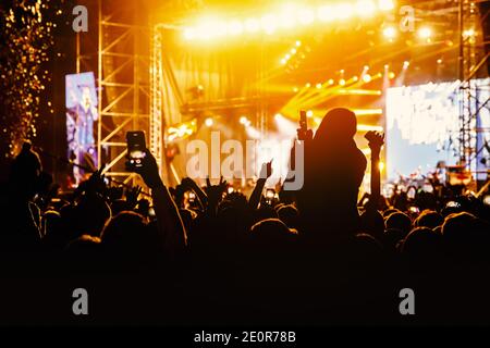 Folla in un concerto. Mani e smartphone davanti al palco Foto Stock