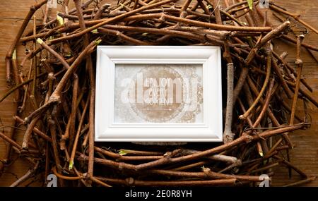 Disposizione fatta di rami con un messaggio in una cornice di legno 'godere ogni momento'. Foto Stock