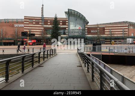 Centro, Oberhausen, NRW, Germania. 02 gennaio 2021. Una famiglia cammina lungo un ingresso desertato dove migliaia di persone normalmente passeggiano, carichi di borse per lo shopping. Il più grande centro commerciale della Germania e i ristoranti, i caffè e i divertimenti circostanti appaiono sgarbati e desertati, le entrate sono chiuse e chiuse. Il popolare centro commerciale con 125.000 m² di spazio commerciale e l'intera area all'aperto sarebbe normalmente un grande paradiso per gli acquirenti alla ricerca di occasioni nelle vendite di gennaio. Credit: Imageplotter/Alamy Live News Foto Stock