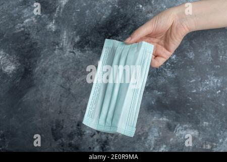 Maschera di protezione per la tenuta della mano femmina Foto Stock