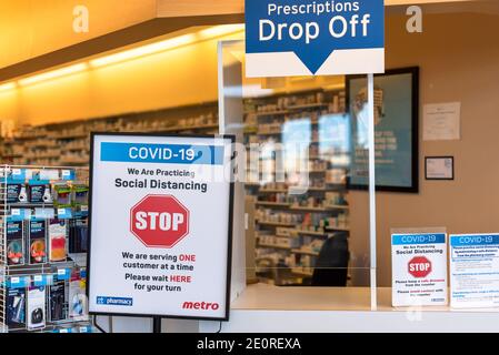 Toronto, Ontario, Canada-2 aprile 2020: Barriera in plexiglass e avvisi in farmacia. La città, le imprese, e le persone private stanno assumendo Extreme sa Foto Stock