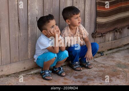 Sanli Urfa, Turchia - Settembre 12 2020: Due ragazzi seduti per strada e guardando con attenzione Foto Stock