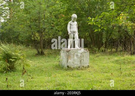 Antica scultura di bambini in un campo di pionieri abbandonato. Foto Stock