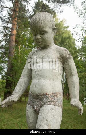 Antica scultura di bambini in un campo di pionieri abbandonato. Foto Stock