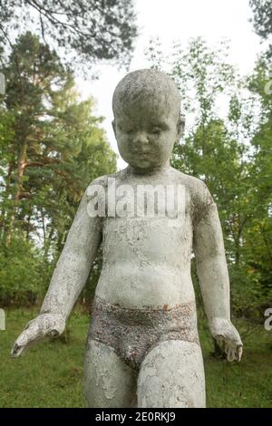 Antica scultura di bambini in un campo di pionieri abbandonato. Foto Stock