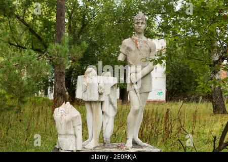 Antica scultura di bambini in un campo di pionieri abbandonato. Foto Stock