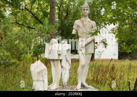 Antica scultura di bambini in un campo di pionieri abbandonato. Foto Stock