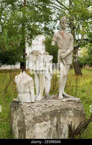 Antica scultura di bambini in un campo di pionieri abbandonato. Foto Stock