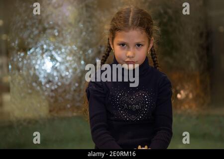 Una bambina bionda guarda attentamente in lontananza. Foto Stock