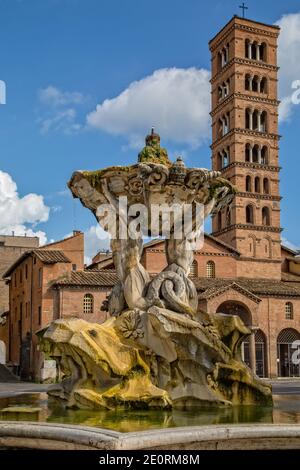 Fontana del Tritone con la chiesa di Santa Maria in Cosmedin che ospita la bocca della Verità a Roma, Italia Foto Stock