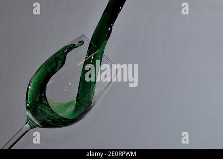 liquido verde versato in un wineglass selvaggio Foto Stock