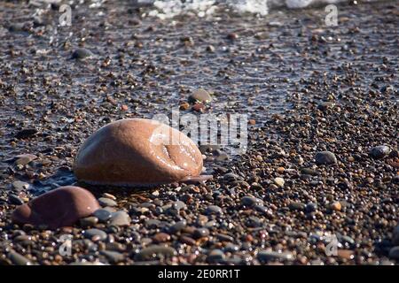 Set di rocce sulla riva della spiaggia, sfondo non focalizzato, nessuno, primo piano, soleggiato, grandi e piccole pietre Foto Stock