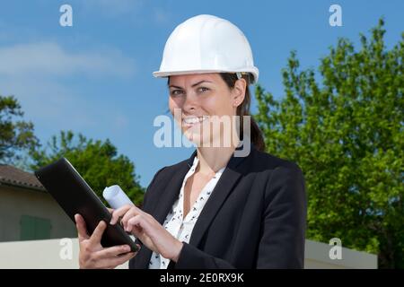 project manager che utilizza un tablet all'esterno di una proprietà Foto Stock