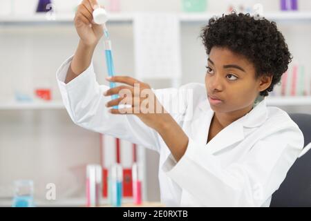 giovane donna scienziata che lavora con una pipetta in una laboratoy Foto Stock