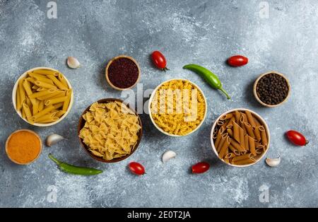 Diversi tipi di maccheroni e verdure crude Foto Stock