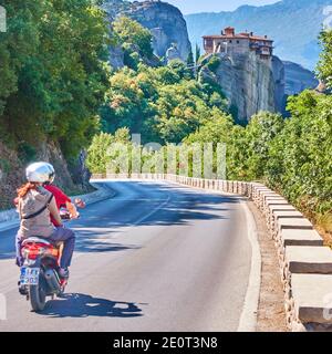 Kalamaka, Grecia - 18 settembre 2019: Scooter a motore con turisti sulla strada per il monastero di Rousanou a Meteora, Grecia. Foto Stock