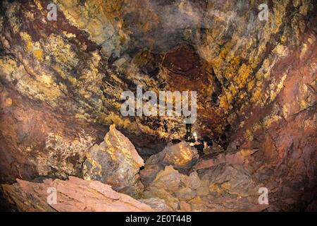 Un uomo (MR) all'interno di una enorme caverna che fa parte di un lungo tubo di lava sull'isola di Maui, Hawaii. Foto Stock