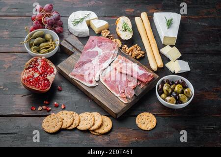 Tavolo di antipasti con diversi antipasti, su sfondo di legno scuro Foto Stock