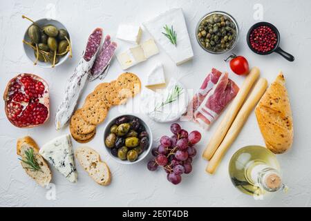 Tavolo per antipasti con diversi antipasti, su sfondo bianco, piatto Foto Stock