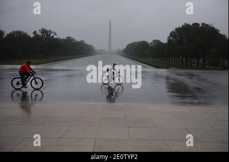 Le persone che cavalcano le biciclette combattono gli alti venti e la pioggia dell'uragano Sandy al Lincoln Memorial a Washington, DC, USA, 29 ottobre 2012. I venti superiori di Sandy aumentano a 90 mph. Foto di Olivier Douliery/ABACAPRESS.COM Foto Stock