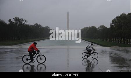 Le persone che cavalcano le biciclette combattono gli alti venti e la pioggia dell'uragano Sandy al Lincoln Memorial a Washington, DC, USA, 29 ottobre 2012. I venti superiori di Sandy aumentano a 90 mph. Foto di Olivier Douliery/ABACAPRESS.COM Foto Stock