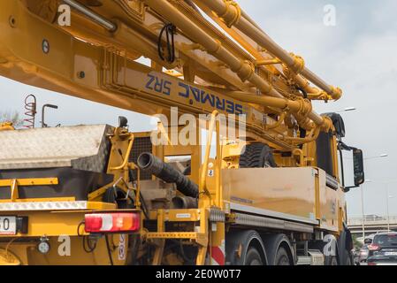 Varsavia, Polonia - 29 aprile 2020: Camion giallo con pompa per calcestruzzo e braccio. Tecnologie di costruzione. Foto Stock