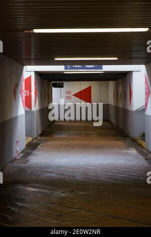 Tunnel della stazione con frecce direzionali Foto Stock