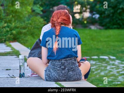 Amici di ragazza che prendono una pausa in città Foto Stock