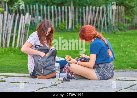 Amici di ragazza che prendono una pausa in città Foto Stock