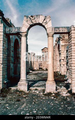 Dougga (Thugga) - Sito Archeologico nel nord della Tunisia, rovine di Berber, punico e insediamento romano, la piccola città romana meglio conservata nel Nord Africa. Porta alle Terme Liciniane. Scansione di archivio da un vetrino. Aprile 1976. Foto Stock