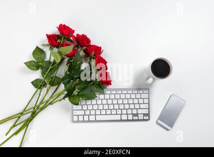Belle rose rosse sul desktop di lavoro per un concetto romantico Come il giorno di San Valentino Foto Stock