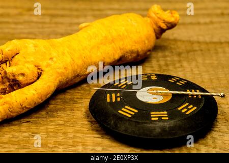 Ago per agopuntura sul simbolo cinese del taoismo con radice di Ginseng Foto Stock